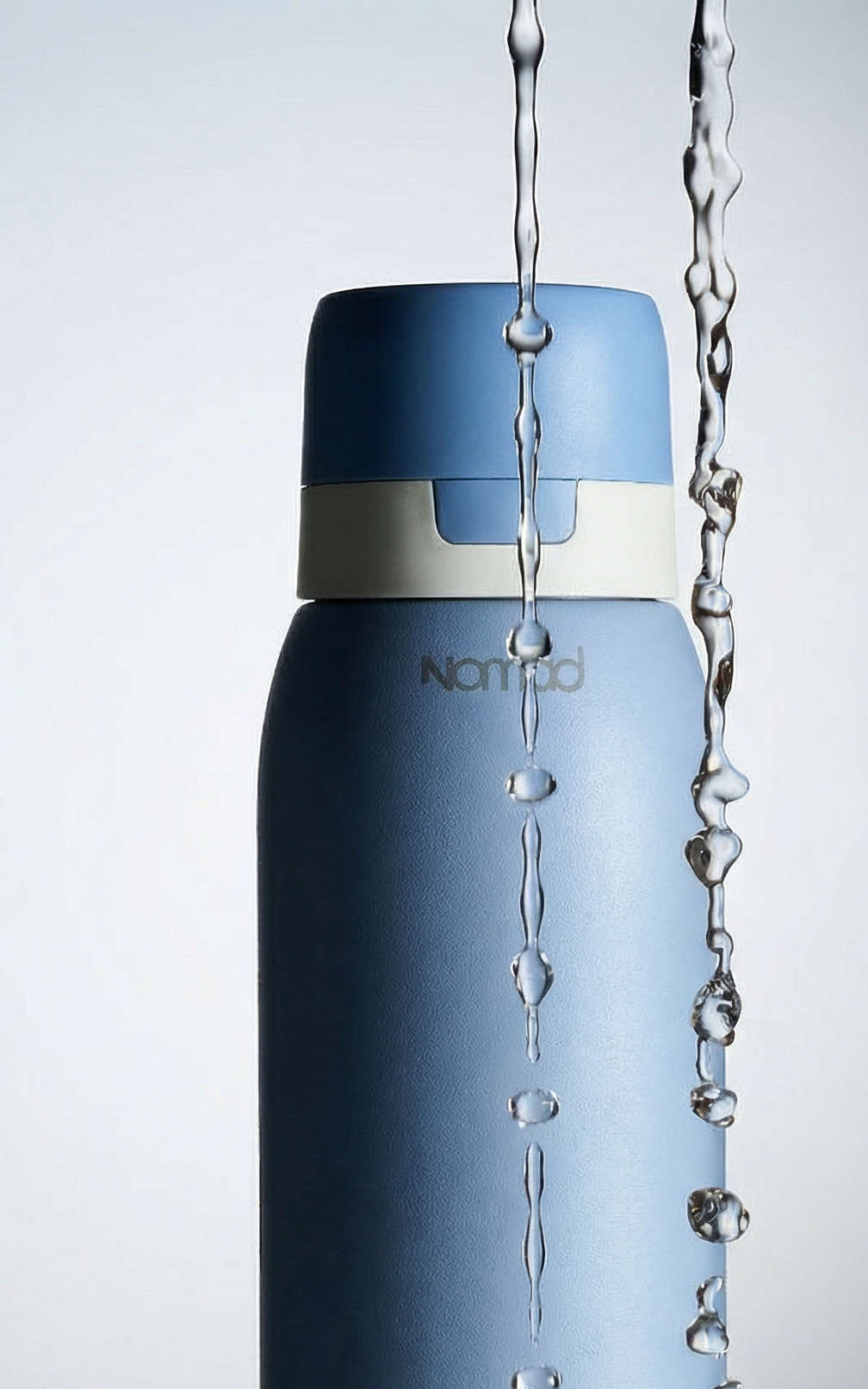 Sky Blue filtered water bottle with water droplets on a gray background