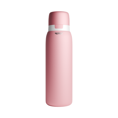 A matte pink NOMAD SafeSip Purifier vacuum-insulated water bottle with a matching pink lid and a white band around the neck, featuring the 'NOMAD' brand logo, set against a plain white background. 